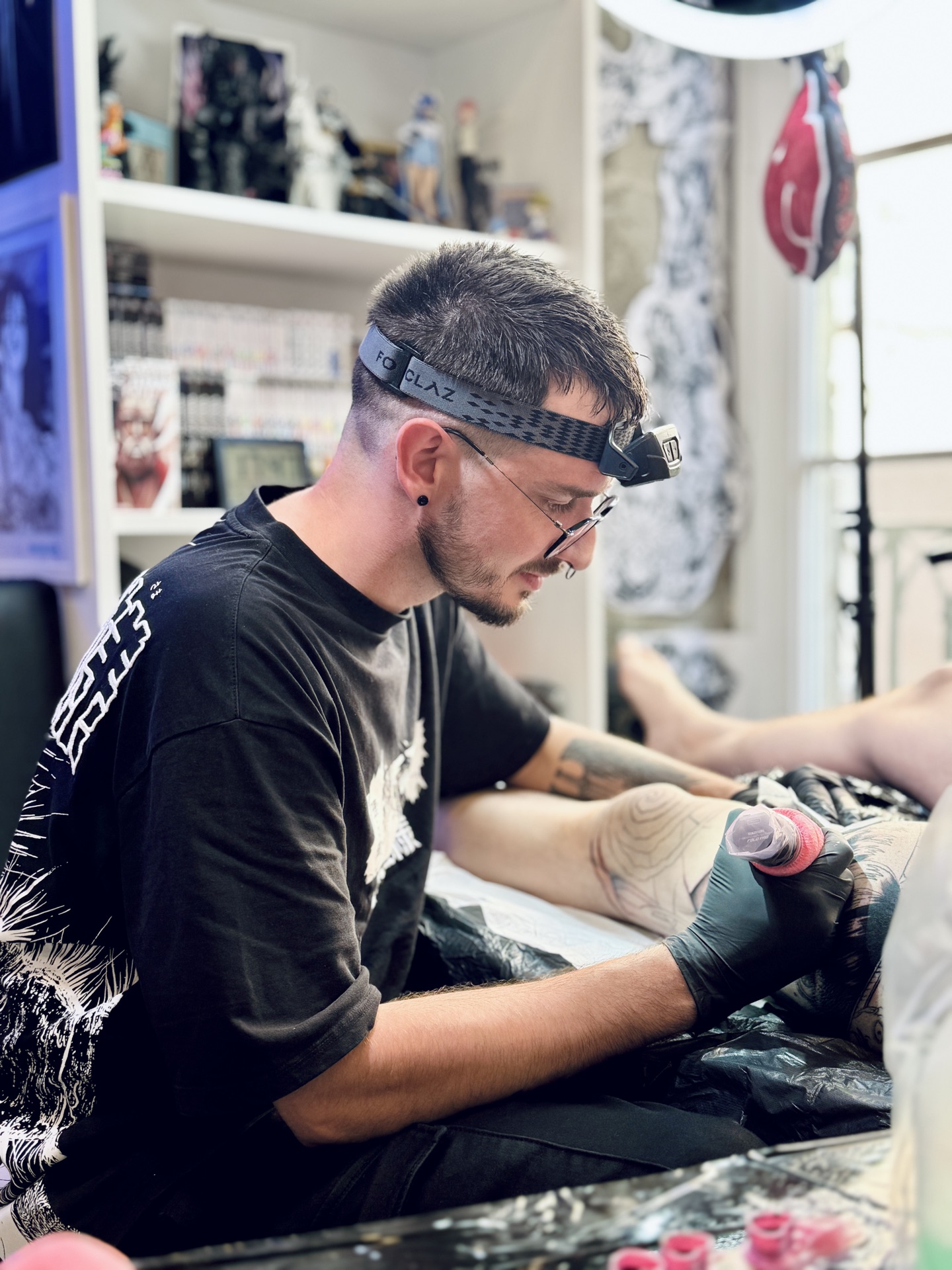 Aks Tattoo au travail dans son studio